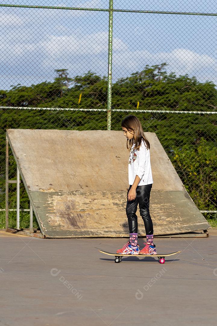 Garota andando de skate em uma quadra Imagem JPG