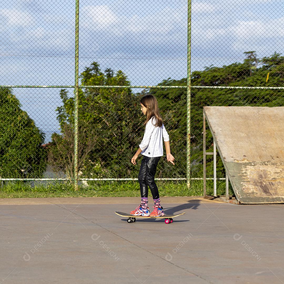 Garota andando de skate em uma quadra Imagem JPG