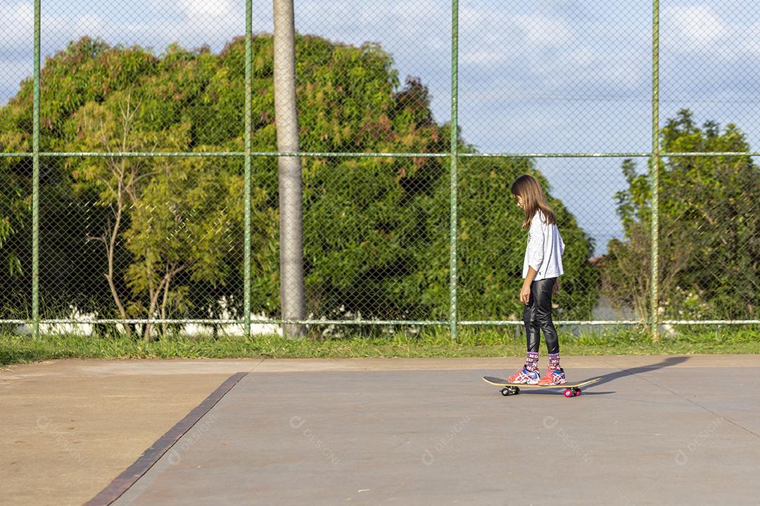 Garota andando de skate em uma quadra Imagem JPG