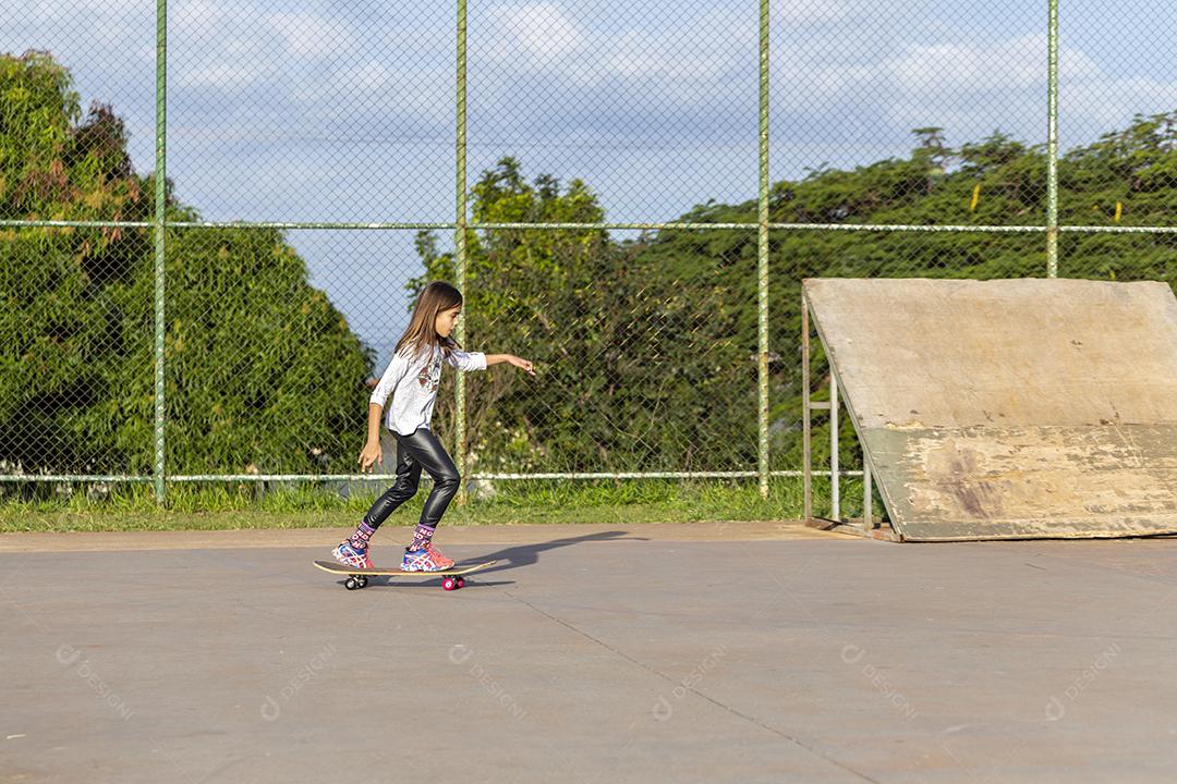 Garota andando de skate em uma quadra Imagem JPG
