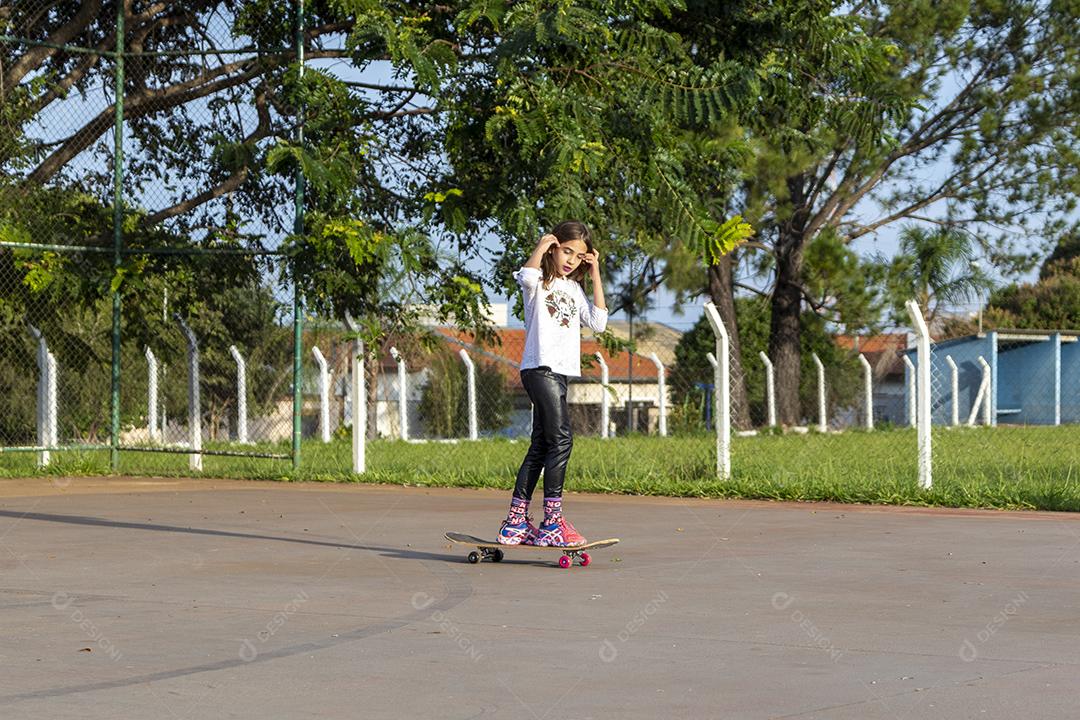 Garota andando de skate em uma quadra Imagem JPG