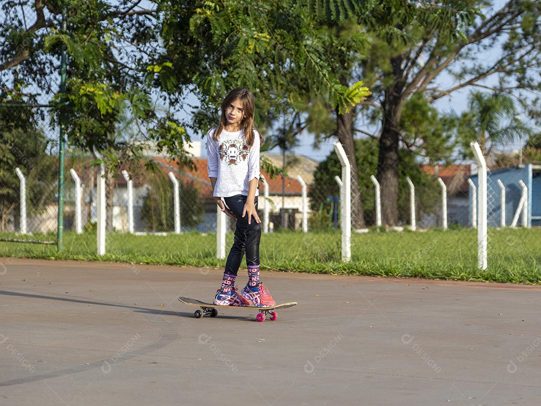 Garota andando de skate em uma quadra Imagem JPG