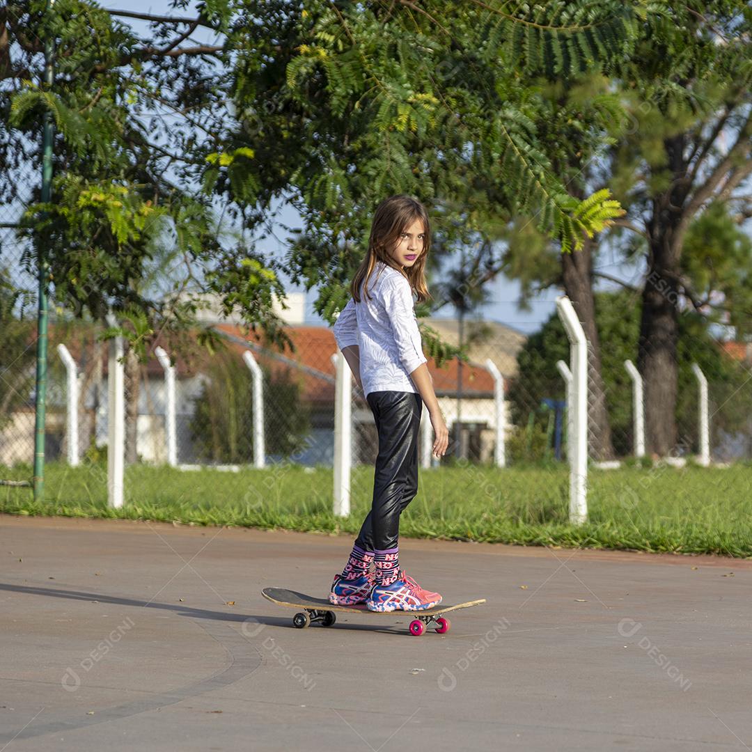 Garota andando de skate em uma quadra Imagem JPG