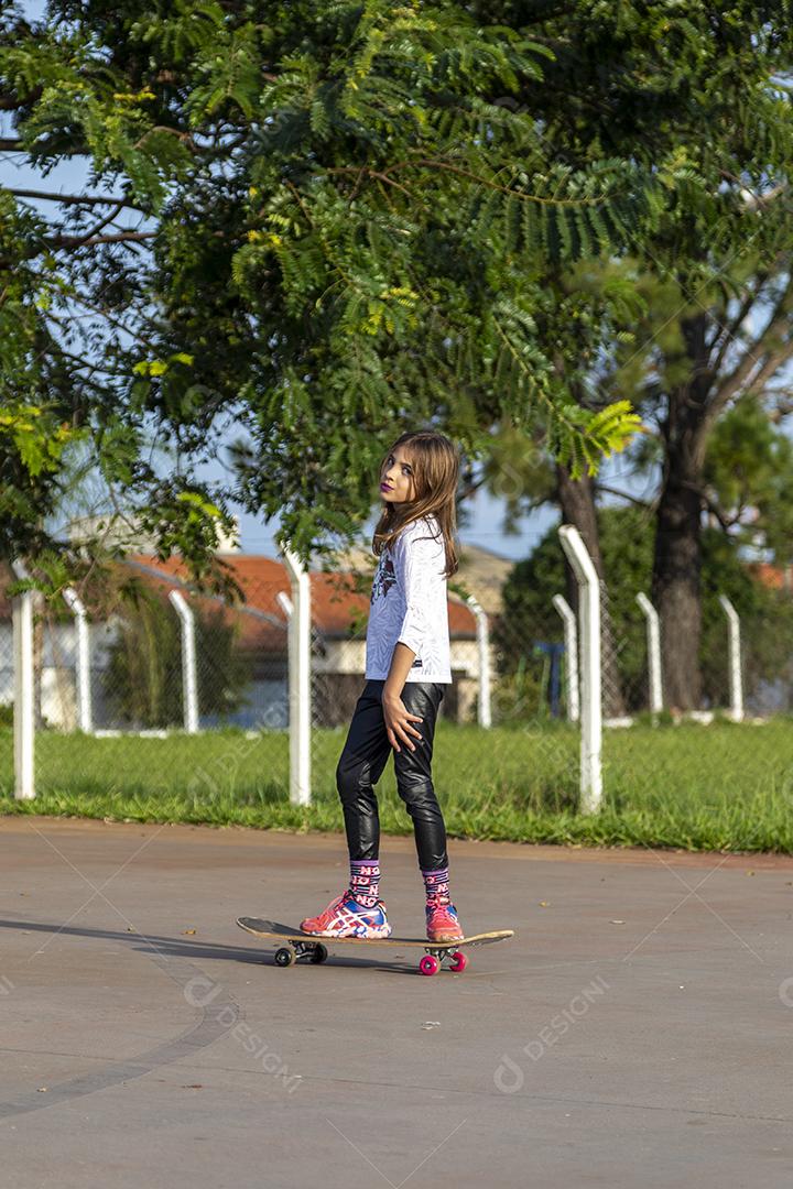 Garota andando de skate em uma quadra Imagem JPG