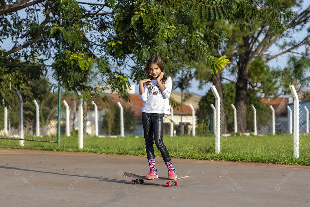 Garota andando de skate em uma quadra Imagem JPG