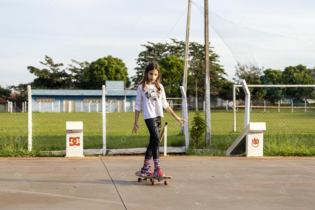 Garota andando de skate em uma quadra Imagem JPG