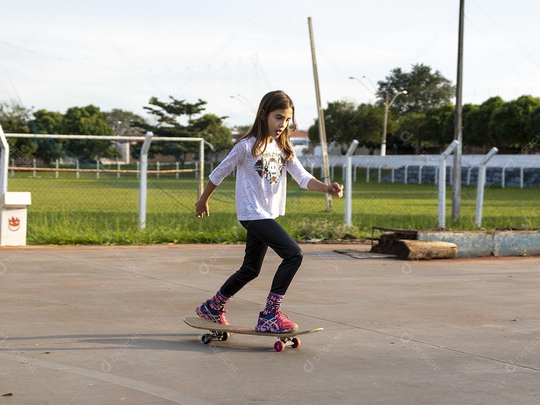 Garota andando de skate em uma quadra Imagem JPG