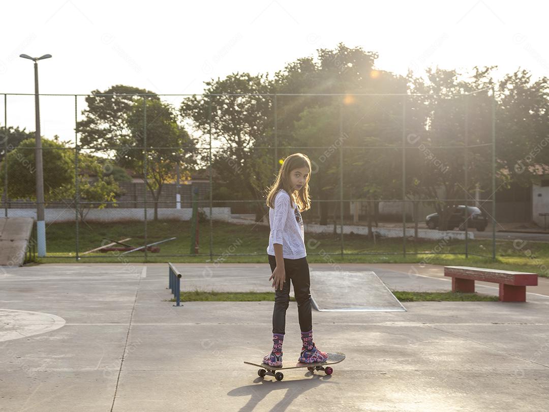 Garota andando de skate em uma quadra Imagem JPG