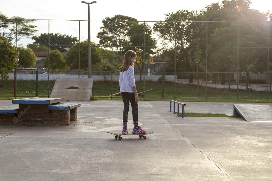 Garota andando de skate em uma quadra Imagem JPG