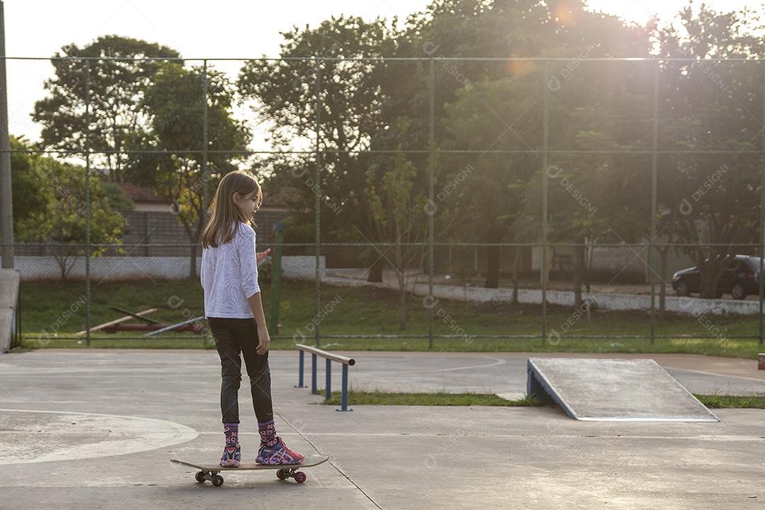 Garota andando de skate em uma quadra Imagem JPG