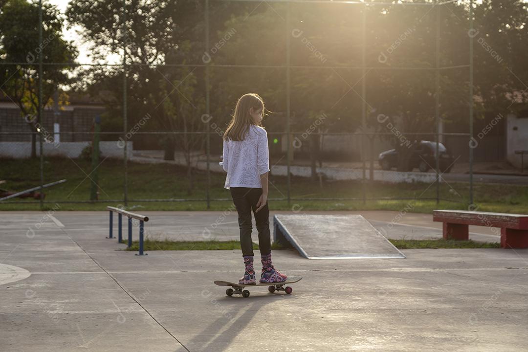 Garota andando de skate em uma quadra Imagem JPG