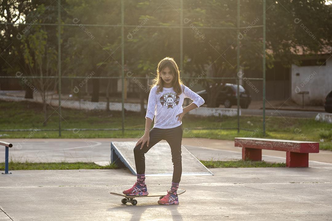 Garota andando de skate em uma quadra Imagem JPG