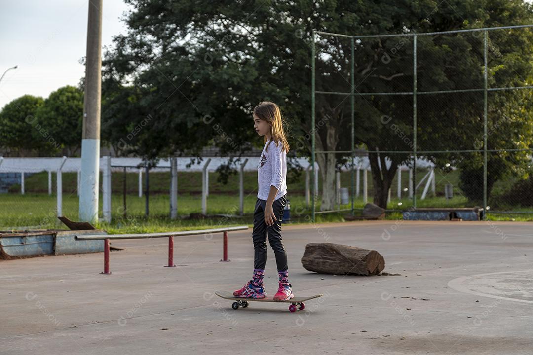 Garota andando de skate em uma quadra Imagem JPG