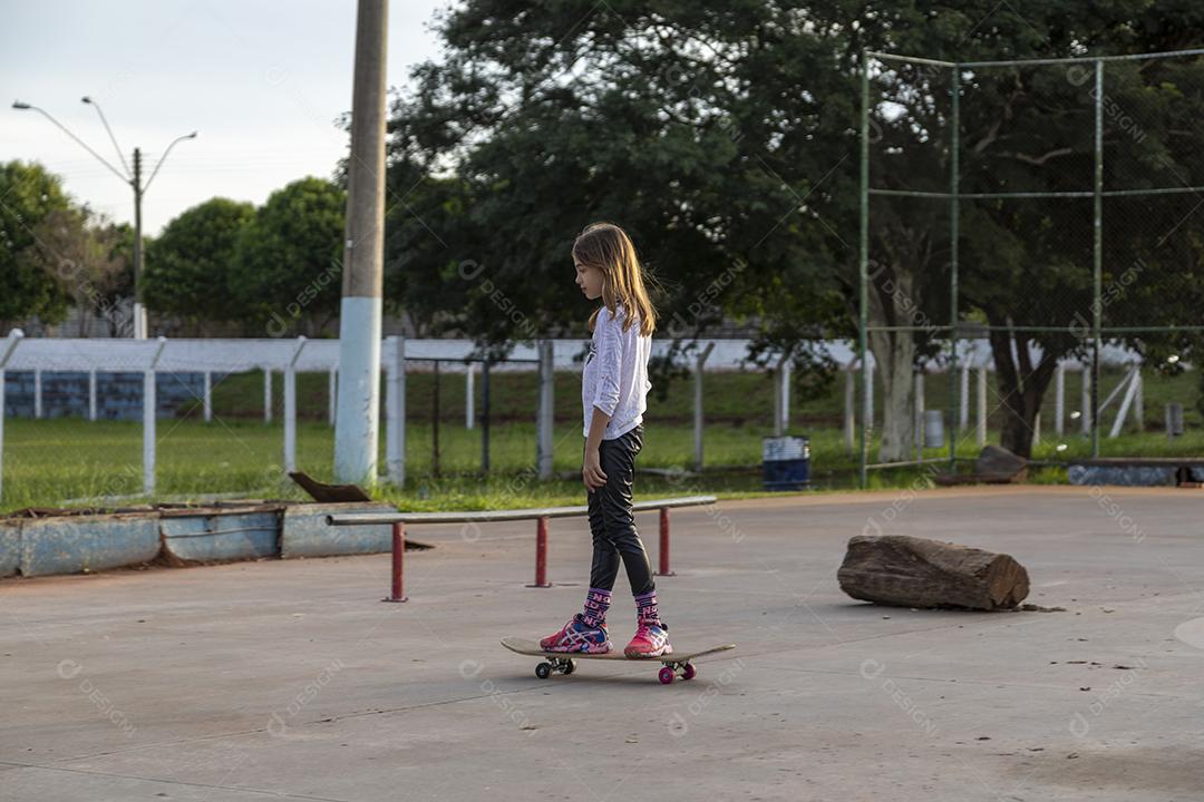 Garota andando de skate em uma quadra Imagem JPG