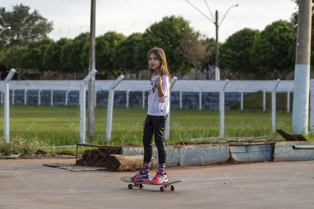 Garota andando de skate em uma quadra Imagem JPG