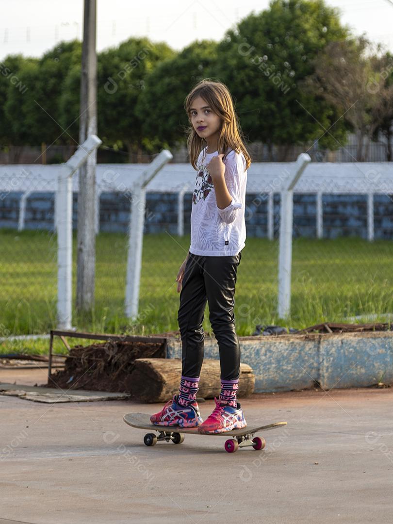 Garota andando de skate em uma quadra Imagem JPG