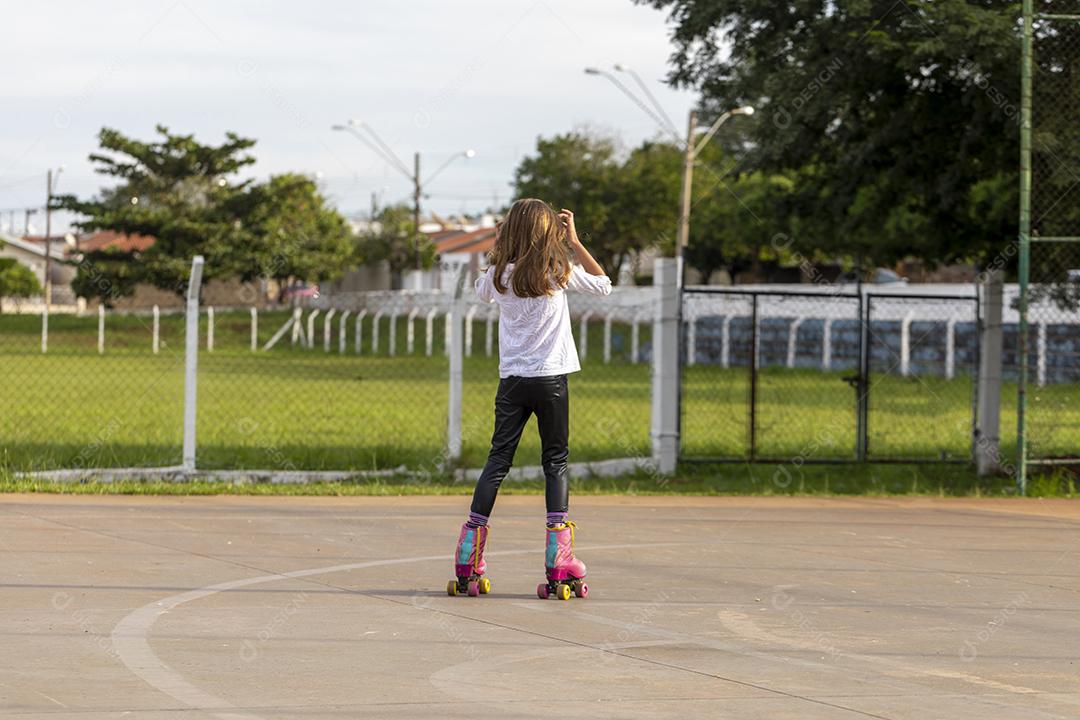 Garota andando de patins em uma quadra Imagem JPG
