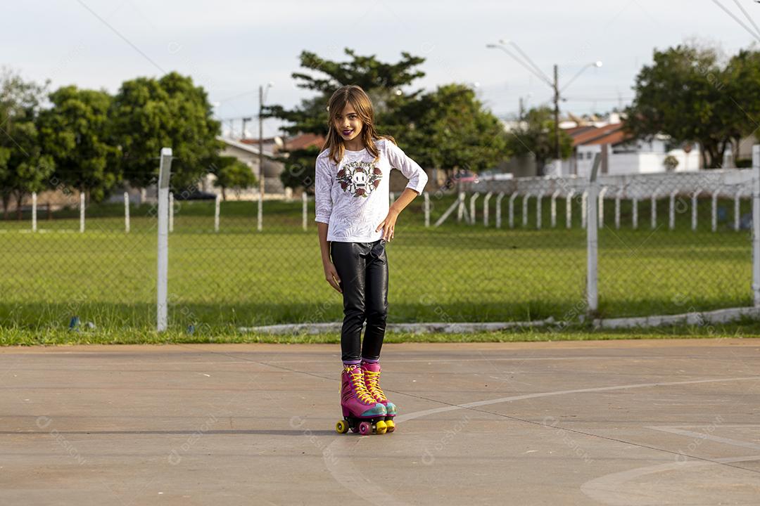 Garota andando de patins em uma quadra Imagem JPG