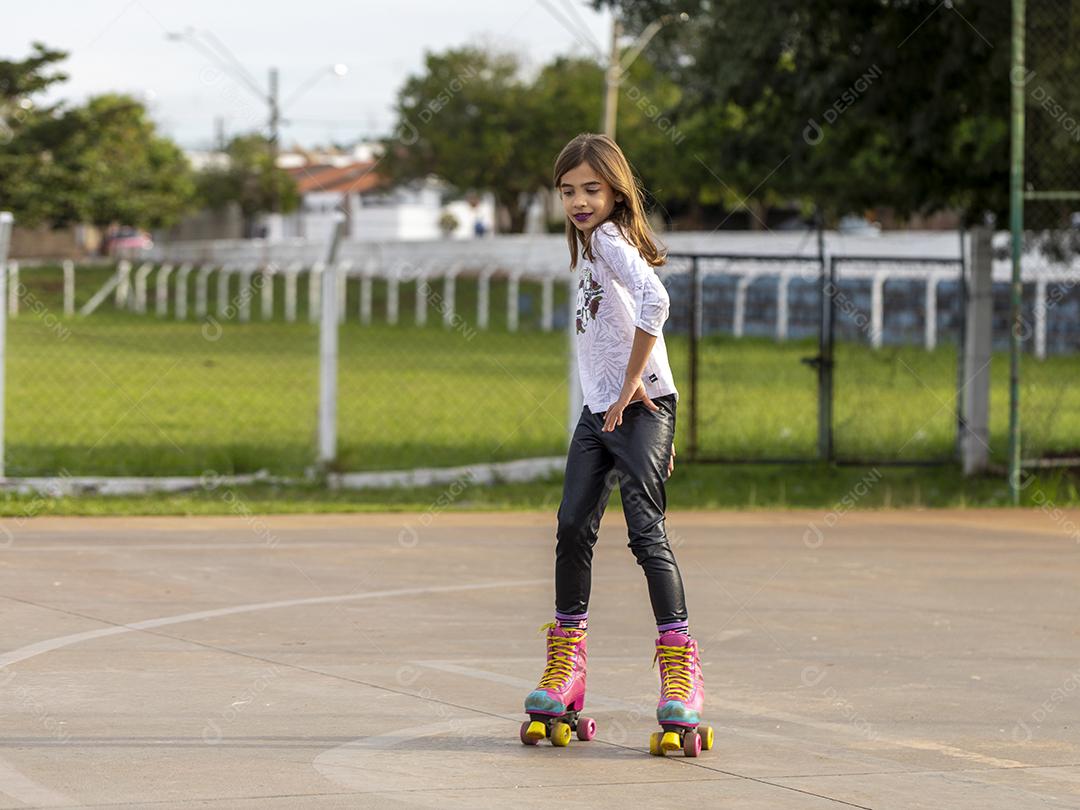 Garota andando de patins em uma quadra Imagem JPG