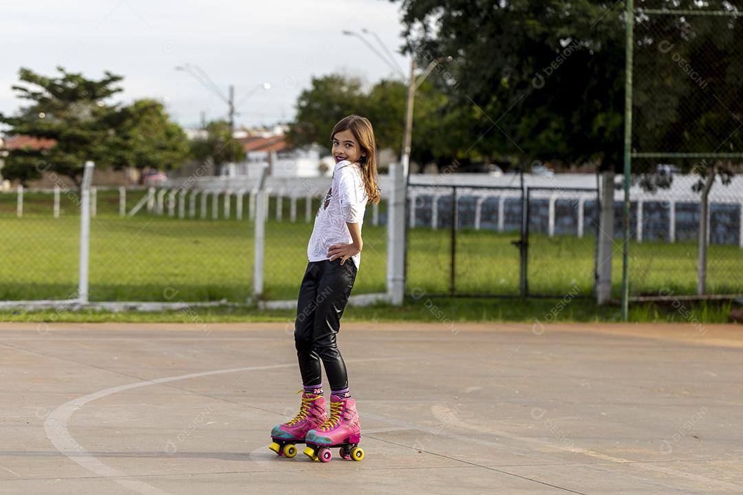 Garota andando de patins em uma quadra Imagem JPG