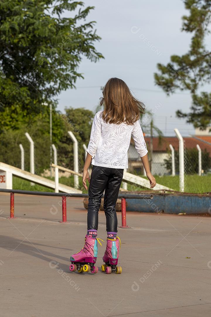Garota andando de patins em uma quadra Imagem JPG