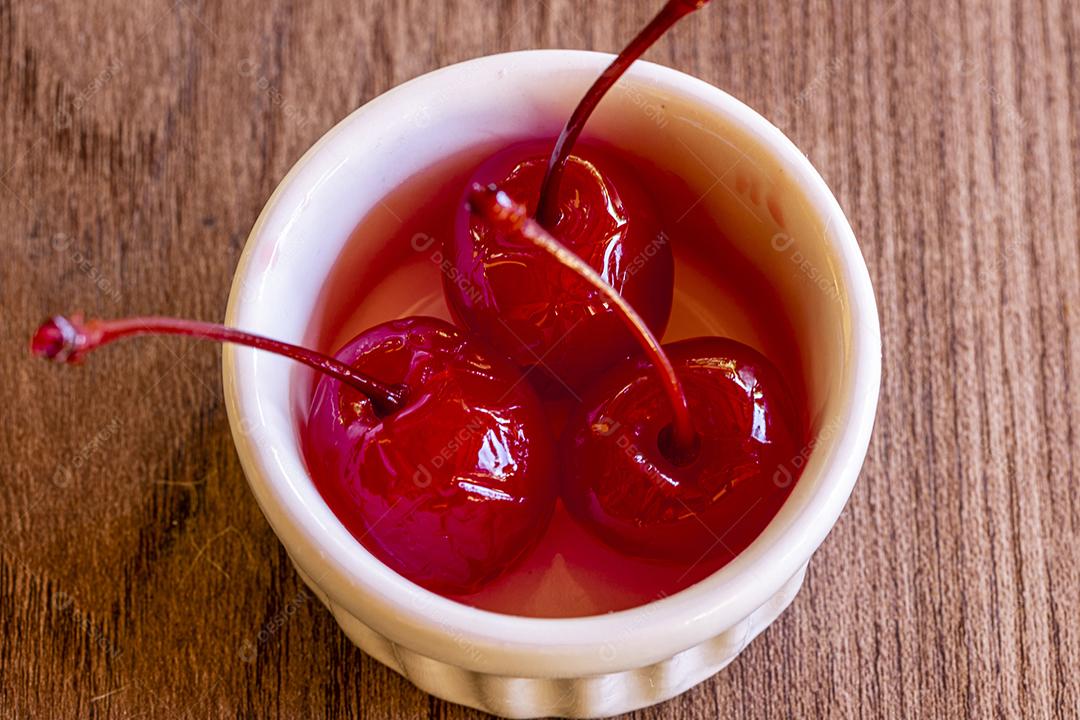 Deliciosas cerejas em tigela sobre fundo de madeira Imagem JPG