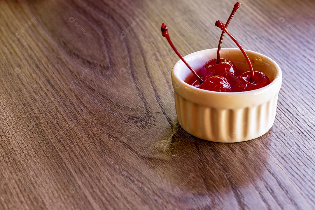 Deliciosas cerejas em tigela sobre fundo de madeira Imagem JPG