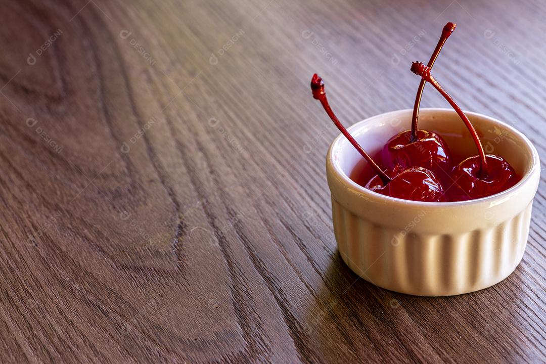 Deliciosas cerejas em tigela sobre fundo de madeira Imagem JPG