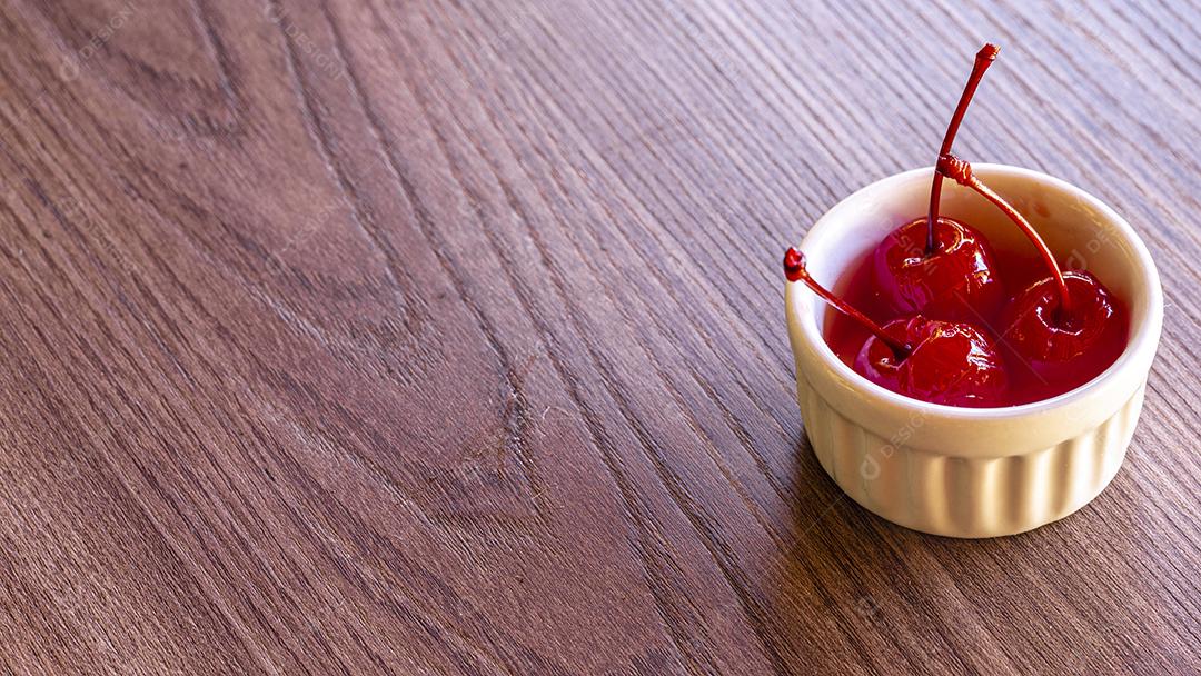 Deliciosas cerejas em tigela sobre fundo de madeira Imagem JPG