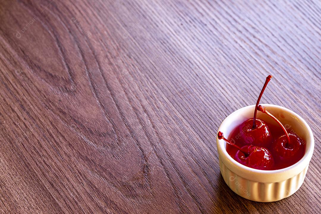 Deliciosas cerejas em tigela sobre fundo de madeira Imagem JPG