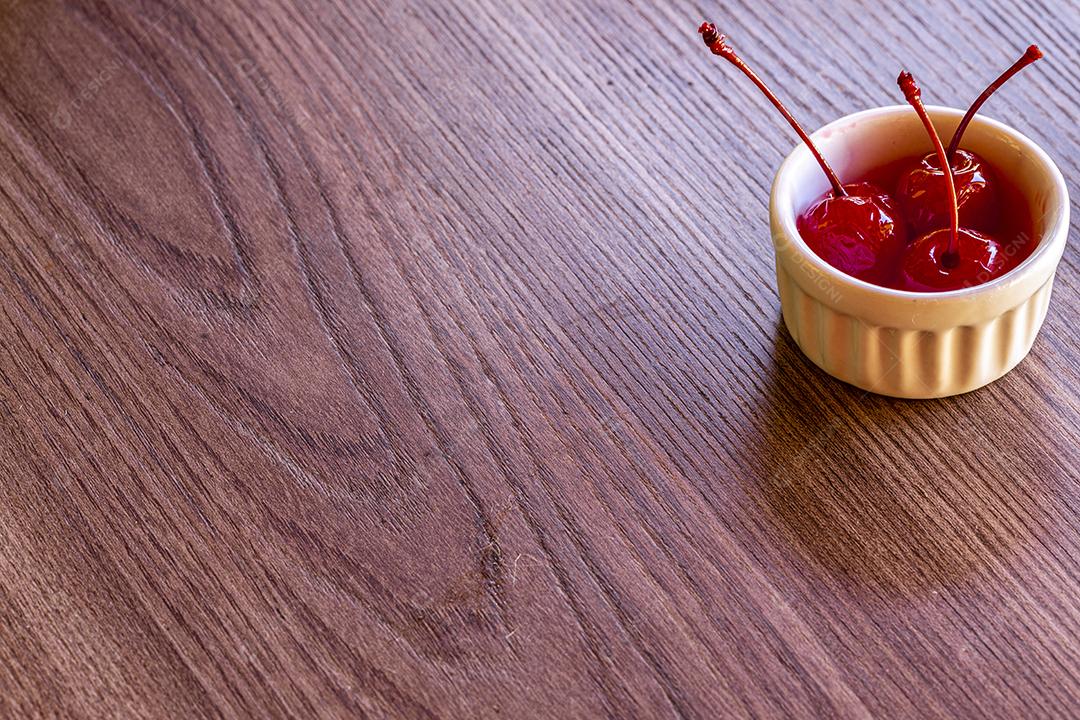 Deliciosas cerejas em tigela sobre fundo de madeira Imagem JPG