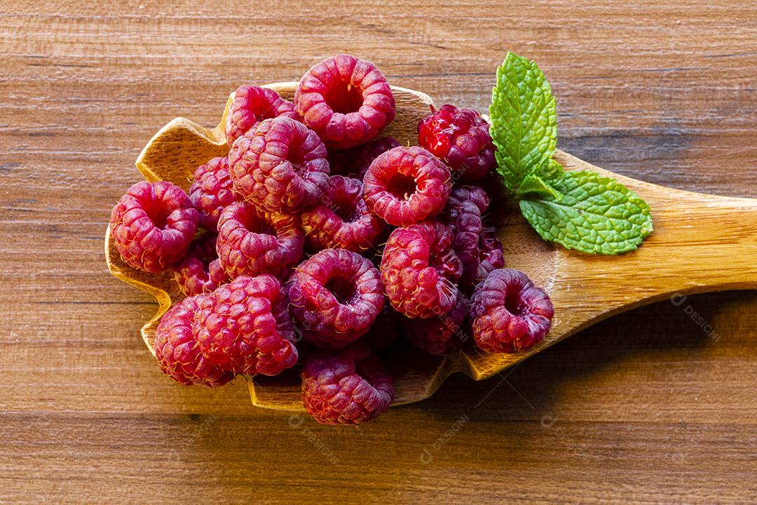 Colher com framboesa de framboesa em fundo de madeira Imagem JPG