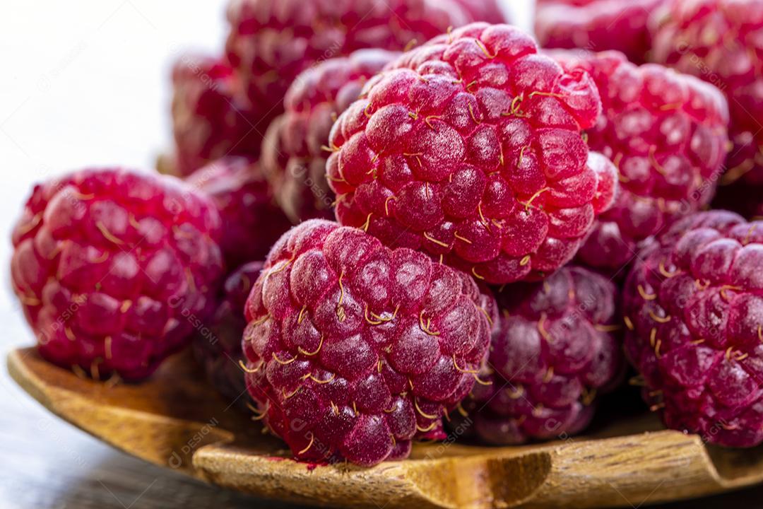 Colher com framboesa e tigela com geléia de framboesa no fundo de madeira Imagem JPG