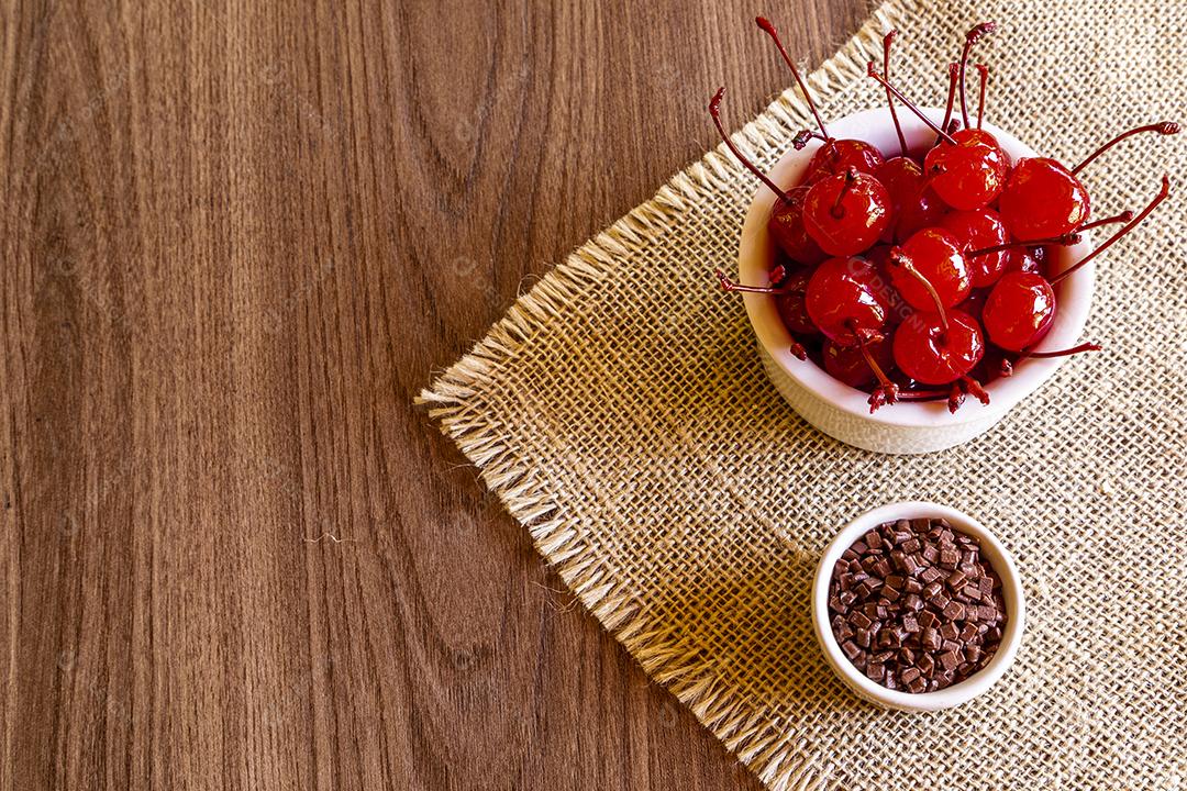 Deliciosas cerejas em tigela sobre fundo de madeira Imagem JPG