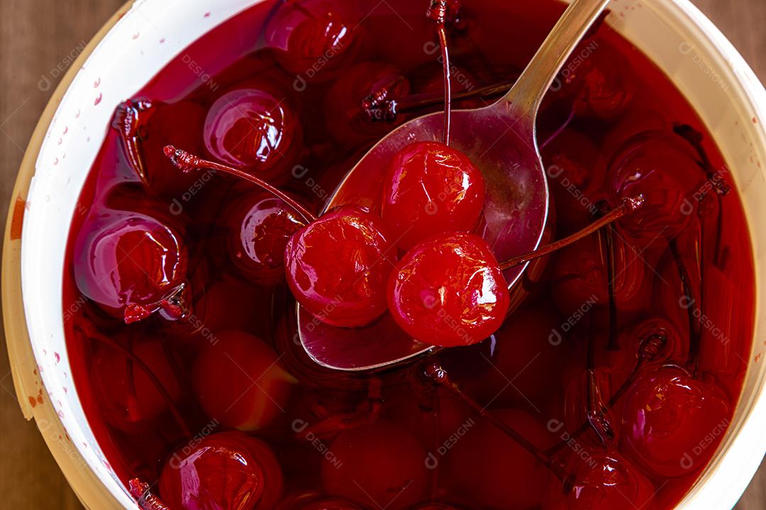 Deliciosas cerejas em tigela sobre fundo de madeira Imagem JPG