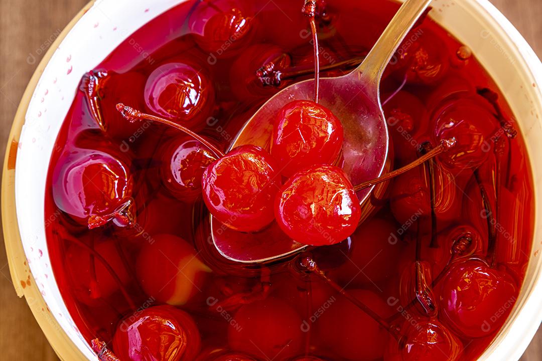 Deliciosas cerejas em tigela sobre fundo de madeira Imagem JPG