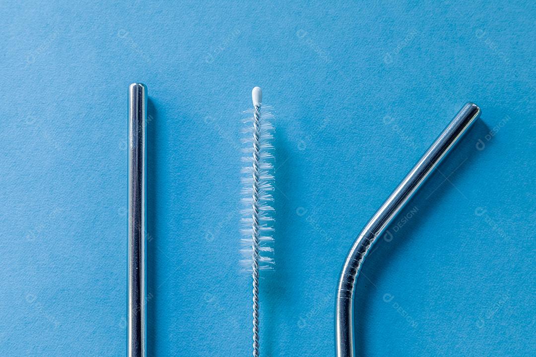 canudos de aço inoxidável reutilizáveis ​​e escova de limpeza em fundo azul Imagem JPG