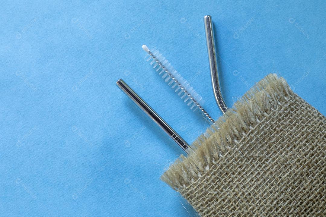 canudos de aço inoxidável reutilizáveis ​​e escova de limpeza em fundo azul Imagem JPG