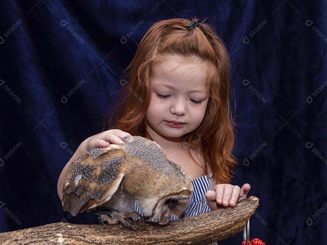 Linda garota ruiva tirando foto com sua coruja de estimação Imagem JPG