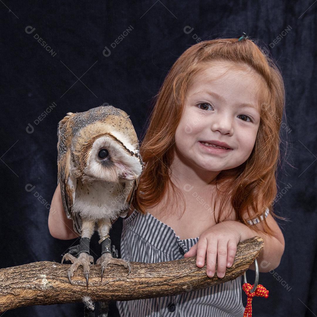 Linda garota ruiva tirando foto com sua coruja de estimação Imagem JPG