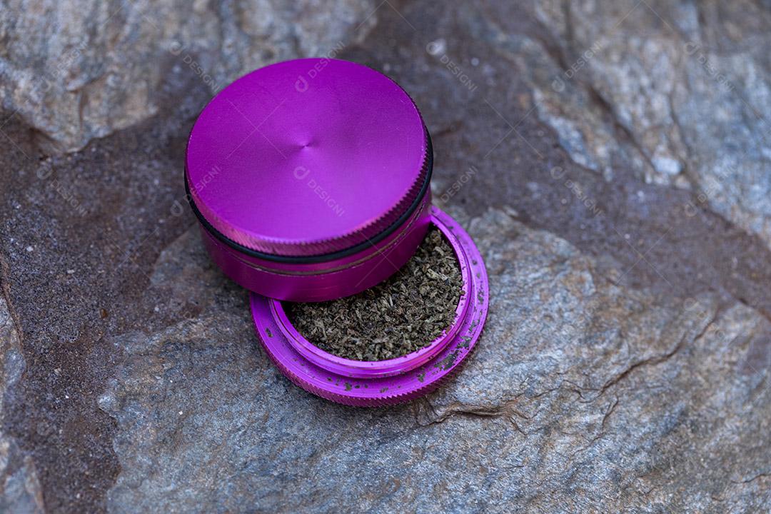 Pedaço de maconha no moedor de ervas pronto para ser esmagado e fumado Imagem JPG