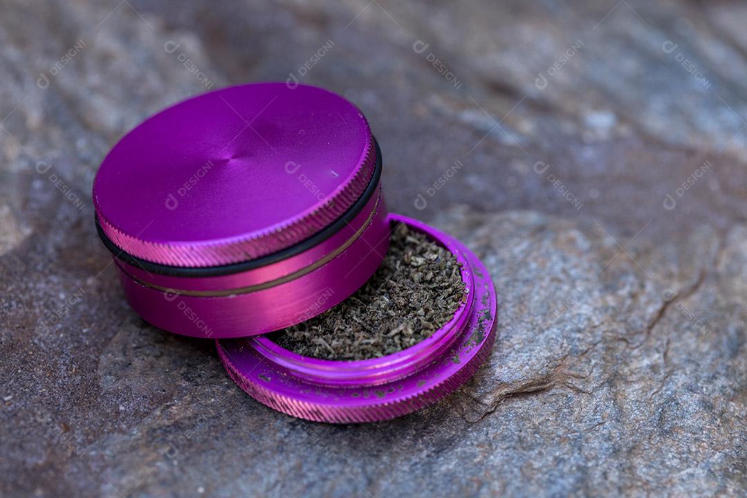 Pedaço de maconha no moedor de ervas pronto para ser esmagado e fumado Imagem JPG