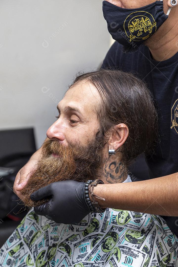 Barbeiro aplicando creme na barba do cliente Imagem JPG
