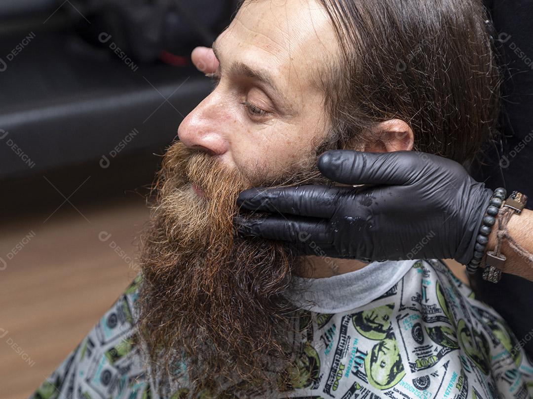 Barbeiro aplicando creme na barba do cliente Imagem JPG