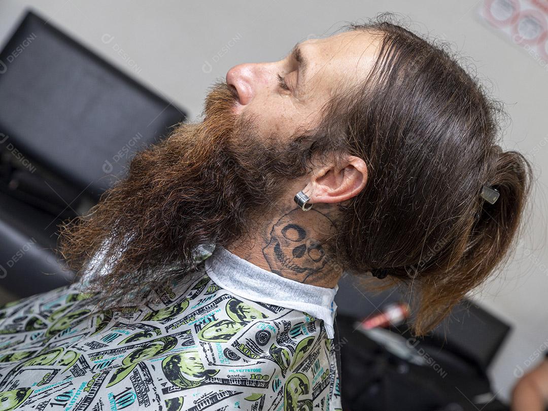 Homem peludo e barbudo na barbearia.Imagem JPG