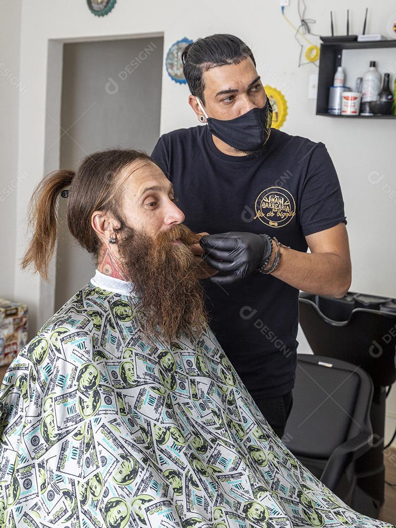 homem na barbearia com barba e cabelo grande fotos imagem