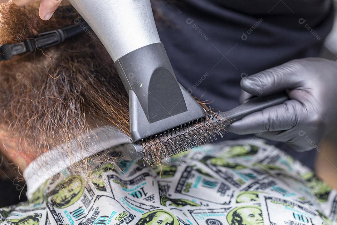 Homem secando a barba no barbeiro.Imagem JPG