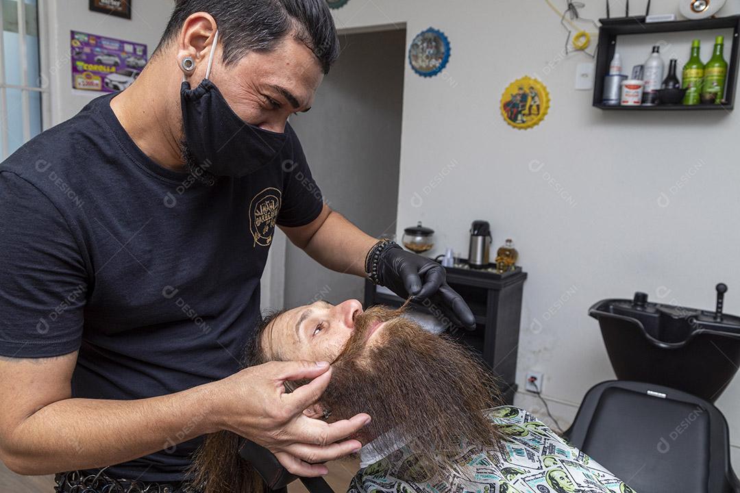 Barbeiro cortando o bigode de um homem.Imagem JPG