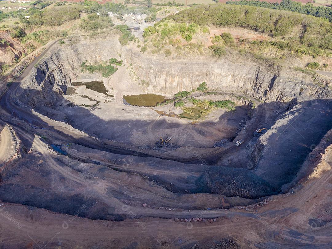 Fotos Tratores e caminhões removendo pedras de dentro de um buraco de pedreira