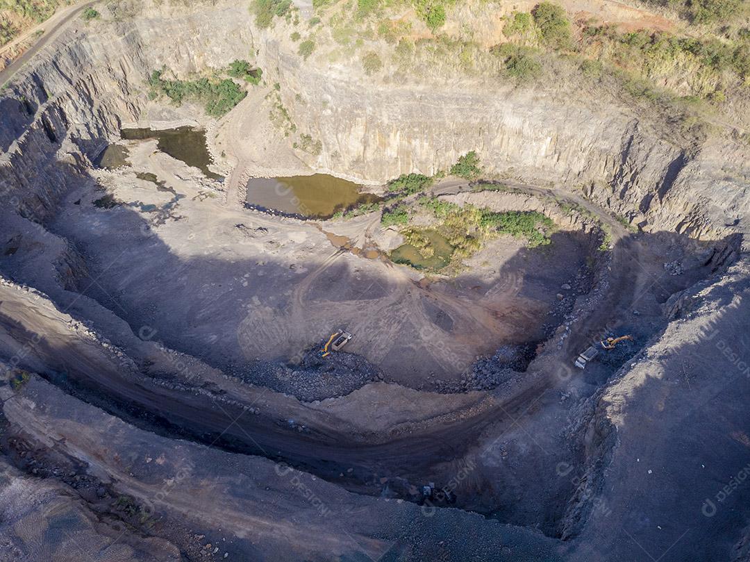 Fotos Tratores e caminhões removendo pedras de dentro de um buraco de pedreira